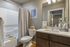 Elegant bathroom with modern fixtures, sleek vanity, and soothing shower area, adorned with stylish decor.