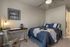 Cozy bedroom featuring a stylish desk, wall art, and plush bedding creating a welcoming and modern atmosphere.