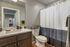 Contemporary bathroom with sleek vanity, polished fixtures, and a stylish shower curtain.