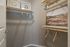 Chic walk-in closet featuring stylish wooden hangers, modern wall art, and ample storage space, ideal for organizing your wardrobe.