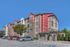 Charming apartment complex with vibrant red accents, ample parking, and inviting communal spaces.