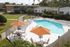 Photo of community swimming pool area with outdoor seating and umbrellas.