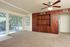 Photo of carpeted living room, screened porch, and oak-styled wall