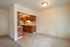 Photo showing galley style kitchen, with dining area and vinyl tile flooring.