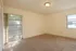 Photo showing carpeted living room, with several windows.