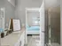 Elegant bathroom with modern shower and view into cozy bedroom with natural light