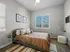 Bright and cozy bedroom with modern decor, large window, and plush bedding.
