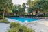 Inviting outdoor pool area surrounded by lush greenery and comfortable lounge chairs.
