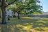 Relaxing courtyard with lush green grass, mature trees, and nearby apartment building, creating a tranquil outdoor space.