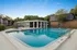 Refreshing outdoor community pool surrounded by lush greenery and modern architecture.