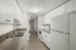 Contemporary kitchen with white cabinets, stainless steel sink, and modern appliances.