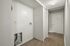 Inviting entry hall with a warm wood floor and ample closet space, featuring a clean and modern aesthetic.