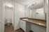 Spacious bathroom with modern fixtures, featuring a large mirror and a sleek countertop.