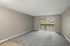 Bright and airy living room with plush carpeting and large window view.