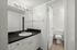 Bright, modern bathroom with sleek black countertop and stylish lighting.