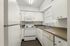 Modern kitchen with white cabinetry, sleek countertops, and essential appliances.