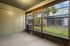 Enclosed patio with a view of a lush, green courtyard in a cozy apartment setting.