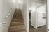 Inviting staircase with plush carpeting leading to a bright, contemporary kitchen area.