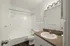 Modern bathroom featuring sleek countertops, a spacious bathtub, and bright lighting.