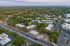 Aerial view of a tranquil residential neighborhood surrounded by lush greenery and accessible roadways.