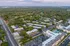 Aerial view of a modern apartment complex surrounded by lush greenery and open spaces.