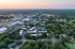 Breathtaking aerial view of a vibrant community nestled among lush greenery and modern architecture at sunset.