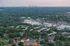 Aerial landscape showcasing a vibrant suburban area with lush greenery and distant city skyline.