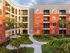 Charming apartment complex with vibrant facade, spacious balconies, and lush landscaped courtyard.
