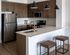 Contemporary kitchen with brown cabinets, stainless steel appliances, and a stylish breakfast bar.