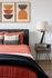 Stylish bedroom featuring modern decor with geometric wall art, a cozy bed with textured covers, and a sleek nightstand with a contemporary lamp.