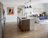 Contemporary open-concept space with a stylish kitchen island, modern decor, and a cozy living area featuring blue and orange accents.