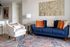 Stylish living room with a navy blue sofa, accent chair, and decorative gold panels.