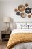 Stylish bedroom with textured decor, modern lamp, and cozy bedding.