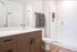 Sleek bathroom featuring a spacious glass shower, elegant vanity, and modern fixtures.