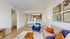 Contemporary living room with cozy seating, stylish decor, and open-plan kitchen.