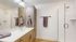 Contemporary bathroom with large mirror, double sink vanity, and glass-enclosed shower.