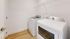 Compact laundry room featuring modern washer and dryer with sleek laminate flooring.