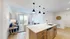 Bright open living space with a modern kitchen island and cozy seating area leading to a balcony.