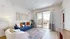 Modern living room with blue sofa, stylish decor, and a balcony view.