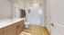 Sleek modern bathroom with a glass-enclosed shower and wood finish cabinets.