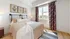 Bright and airy bedroom with stylish decor featuring floral artwork and modern furnishings.
