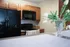 Inviting kitchen with warm wooden cabinets, sleek black appliances, and elegant floral decor on the counter.