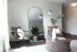 Chic living room with modern seating, large decorative mirror, and elegant lighting creating a cozy atmosphere.