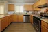 Inviting kitchen with warm wooden cabinets, stainless steel appliances, and sleek countertops.