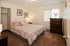 Cozy bedroom with elegant decor featuring a plush bed, warm lighting, and a stylish dresser creating an inviting atmosphere.