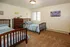 Inviting bedroom with twin beds, stylish wooden furniture, and soft carpet flooring, perfect for comfort and relaxation.