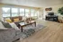 Bright and spacious living room featuring a cozy sectional sofa, large windows, and stylish decor, creating a welcoming and modern atmosphere.
