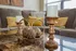 Elegant living room with stylish decor, featuring a marble coffee table adorned with ornate candlesticks and decorative accents, all set against a comfy sofa with plush cushions.