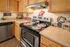 Charming kitchen with warm wooden cabinets, modern stainless steel appliances, and enchanting decor, perfect for culinary enthusiasts.