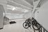Modern apartment amenity featuring a bright, spacious bike storage area with sleek lighting and convenient washing station.